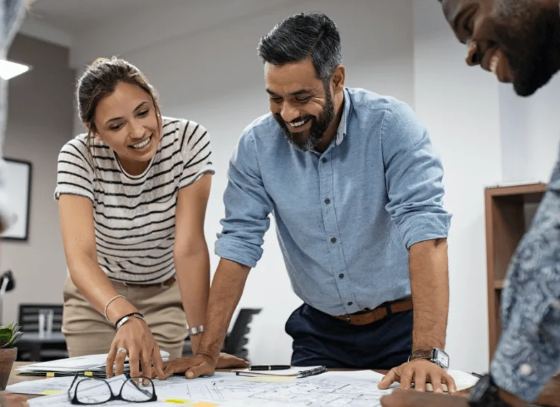 Men and a woman looking at documents on the desk