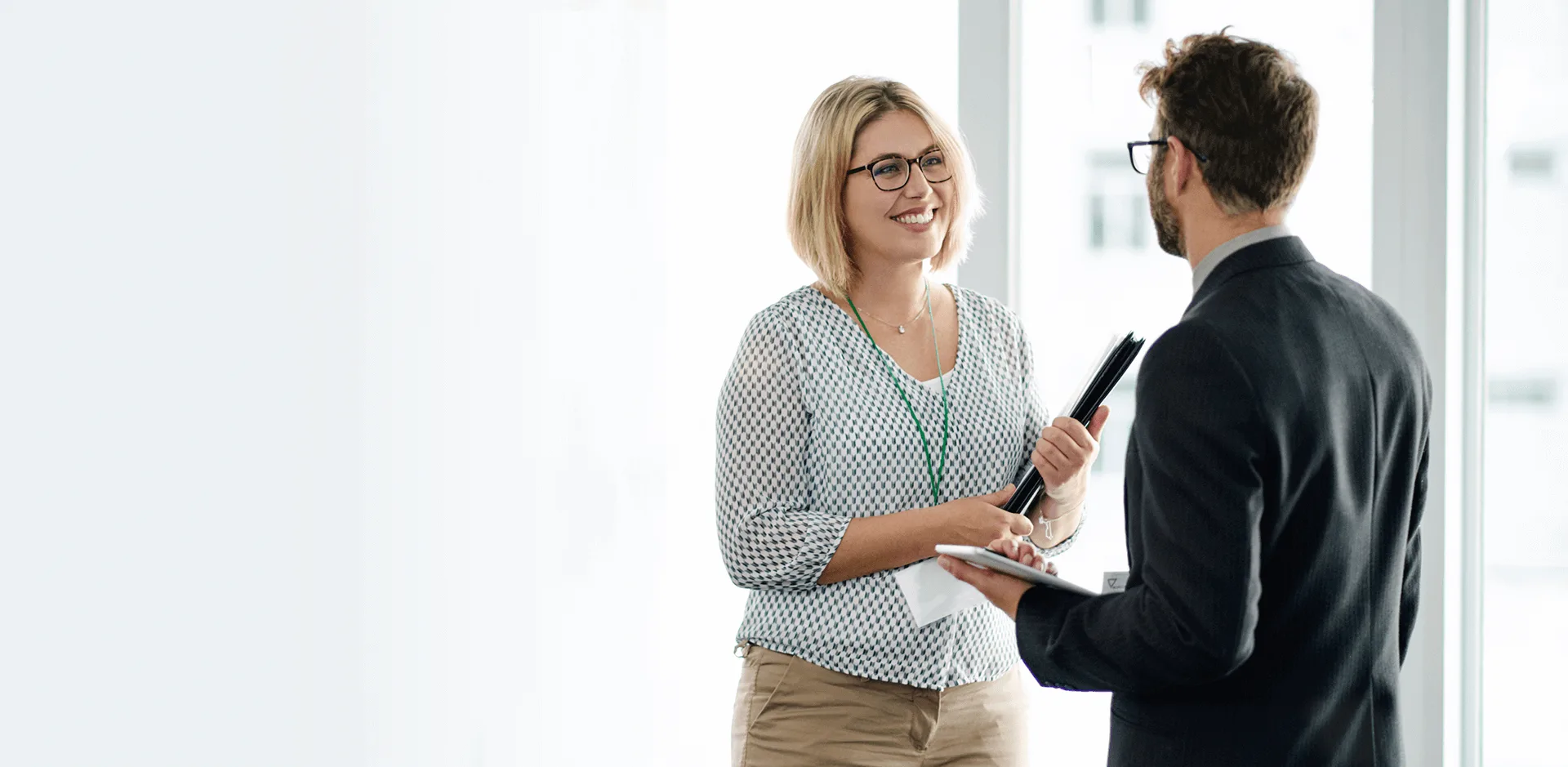 Blonde woman with files talking to a man